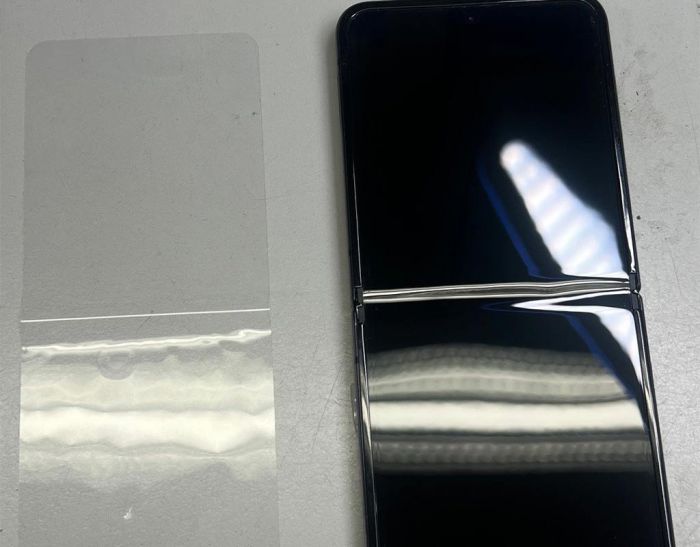 Zuerst wird die alte Folie beim Klapphandy entfernt